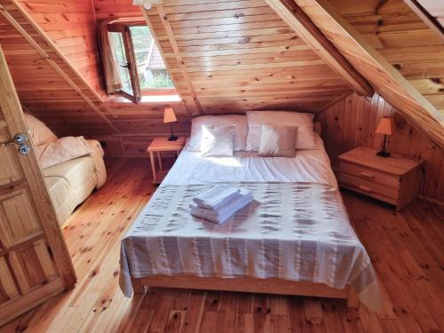 a bedroom with a bed in a wooden cabin at Dom na Mazurach - Willa pod Jaworem in Olsztynek