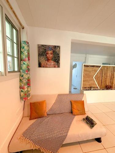 a living room with a couch and a picture on the wall at Kapumati Villa - Évasion en Martinique in Sainte-Anne