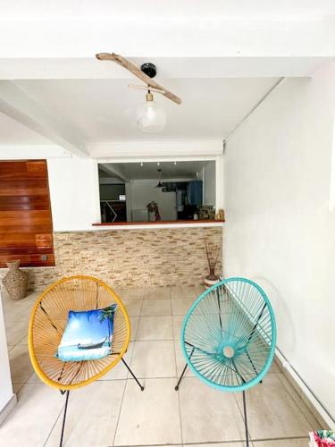 two chairs sitting in a room with a counter at Kapumati Villa - Évasion en Martinique in Sainte-Anne