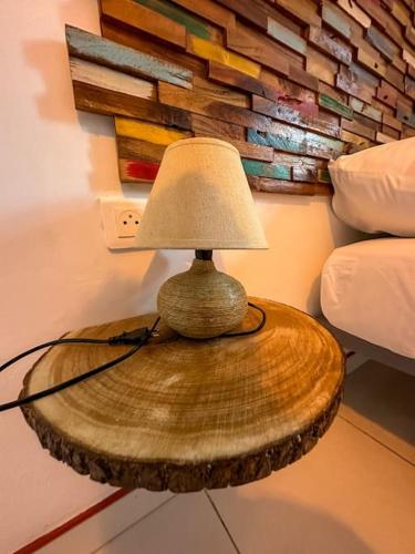 a lamp on a wooden table in a bedroom at Kapumati Villa - Évasion en Martinique in Sainte-Anne