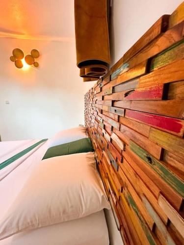a bedroom with a headboard made out of wood at Kapumati Villa - Évasion en Martinique in Sainte-Anne