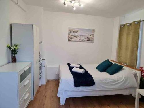 a bedroom with a bed and a dresser and a mirror at Nice Flat near Central London in London
