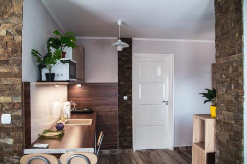 a kitchen with white walls and a counter top at Butik Apartmanház in Fonyód