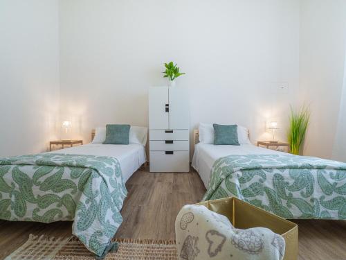 um quarto com duas camas com lençóis verdes e brancos em B&B La Villa 3.0 em Nonantola