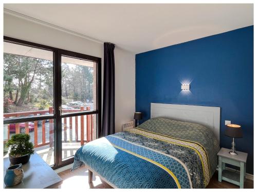 - une chambre bleue avec un lit et un balcon dans l'établissement Escapade au golf de l’Odet, à Bénodet