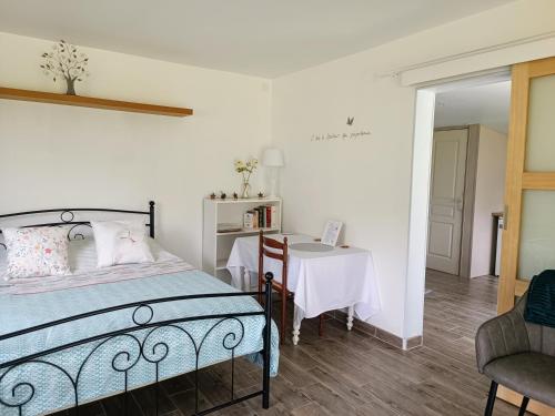 Saint-Pierre-de-BailleulにあるLe Petit Accentのベッドルーム1室(ベッド1台、テーブル、椅子付)