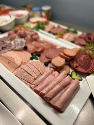 a tray of meats and other foods on a table at Parkhotel Papenburg by Hackmann in Papenburg