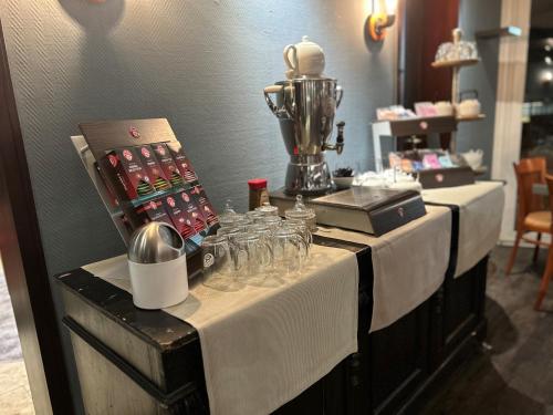 a table with glasses and a blender on top of it at Parkhotel Papenburg by Hackmann in Papenburg