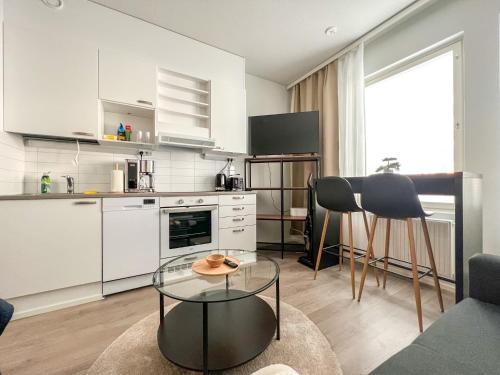 a kitchen and living room with a table and chairs at City Apartment Myllyntupa in Kuopio