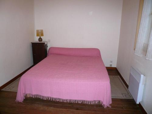 ein rosa Bett in einem kleinen Zimmer mit Fenster in der Unterkunft Le moulin in Préchacq