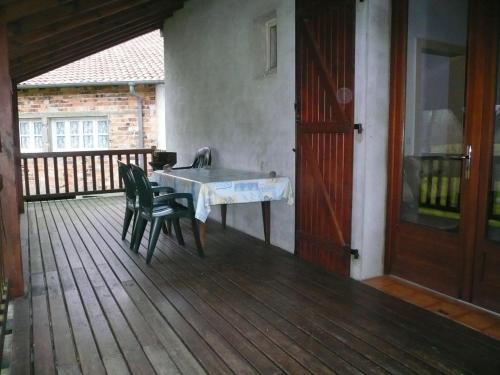 une table et des chaises sur une terrasse avec un évier dans l'établissement Le moulin, à Préchacq-les-Bains