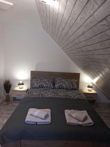 a bedroom with a bed with two towels on it at Happy Guests Residence in Sibiu