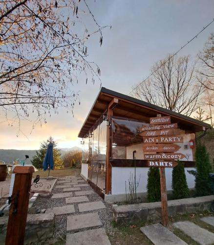 a small building with a sign in front of it at Pensiunea Sara pe deal in Hangul