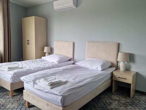 two twin beds in a room with two night stands at Bieszczadzka Pętla Smaków 