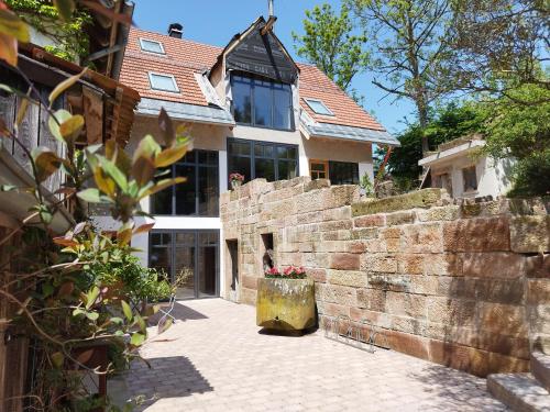 une maison avec un mur et un mur en pierre dans l'établissement Ferienwohnung in den Dorfwiesen, à Gersfeld