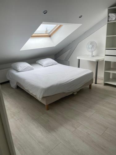 a bedroom with a bed in a attic with a window at Domaine chloé du lac in Montferrat