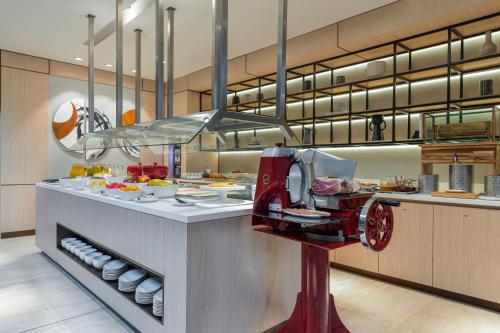 a kitchen with a counter with plates and a food at AC Hotel San Jose Airport Belen in San José