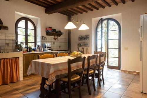 uma cozinha com mesa e cadeiras num quarto em Casa Poggio Agliai basso em Suvereto