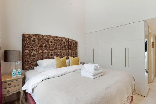 a bedroom with a large bed with towels on it at The Artists Hideaway-2 bed mezzanine in Paddington in London