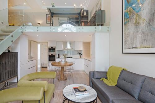 a living room with a couch and a table at The Artists Hideaway-2 bed mezzanine in Paddington in London