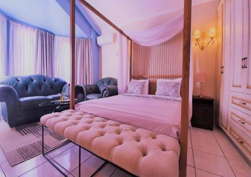 a bedroom with a canopy bed and a couch at Queen Boutique Suites Preveza in Preveza