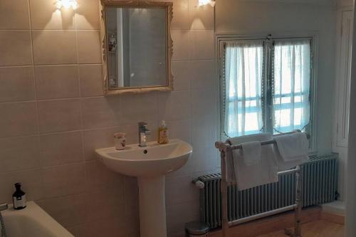 une salle de bain avec un lavabo, un miroir et une baignoire dans l'établissement La maison Belle Marée, à Honfleur