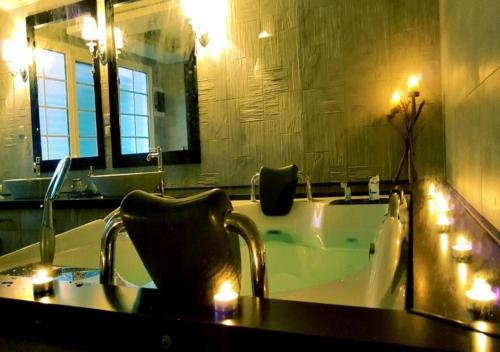 普雷韋扎的住宿－Queen Boutique Suites Preveza，浴室配有带镜子和水槽的浴缸