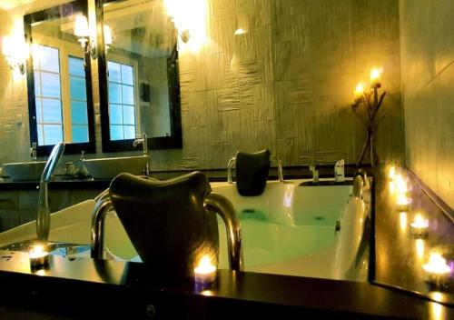 a bathroom with a tub with a mirror and a sink at Queen Boutique Suites Preveza in Preveza