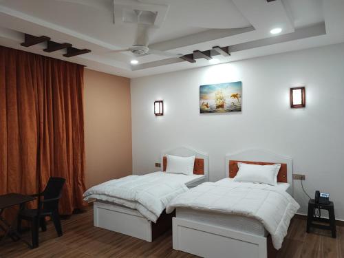 um quarto com duas camas e uma mesa em Dar Al Salaam Hospitality House em Nizwa