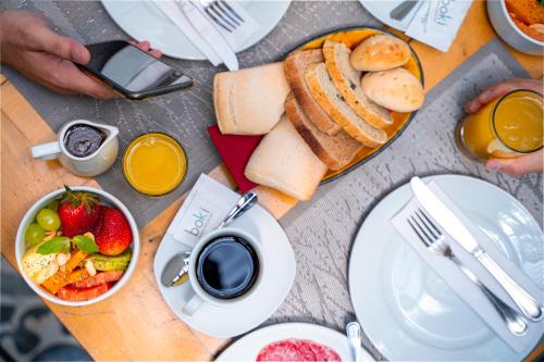 a table with a breakfast of bread and fruit and juice at Rugendas by Time in Santiago