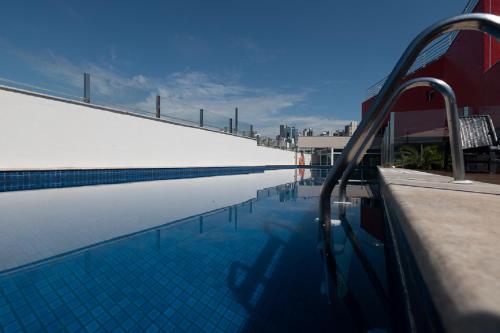 uma piscina ao lado de um edifício em eSuites Virgínia Luxemburgo em Belo Horizonte