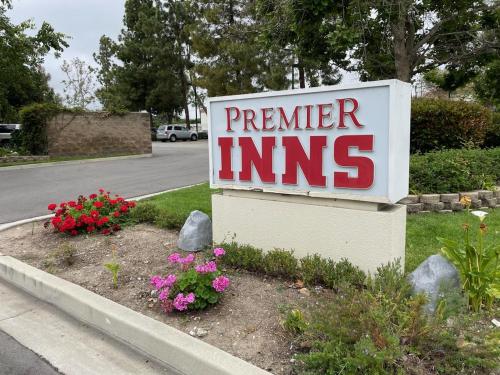 a sign for a premier inn with flowers on the side of a street at Premier Inns Thousand Oaks in Thousand Oaks