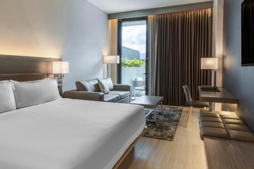 una camera d'albergo con letto e soggiorno di AC Hotel San Jose Airport Belen a San José