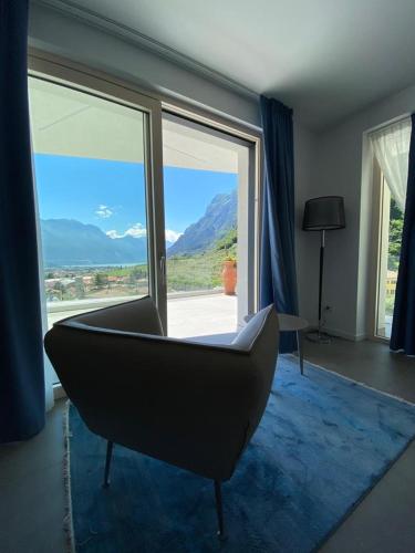 a living room with a chair and a large window at GARNI' FOCI in Riva del Garda