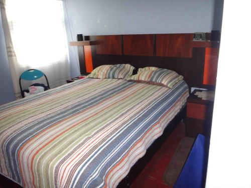 een bed met een gestreept dekbed in een slaapkamer bij Vane House in Lima