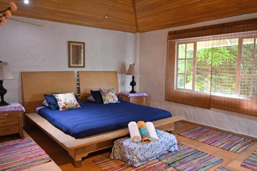 - une chambre avec un lit bleu et une fenêtre dans l'établissement El Canto del Mar, à Santa Marta