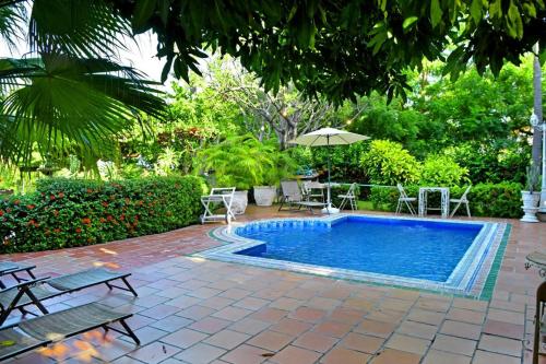 - une piscine avec des chaises et un parasol dans la cour dans l'établissement El Canto del Mar, à Santa Marta