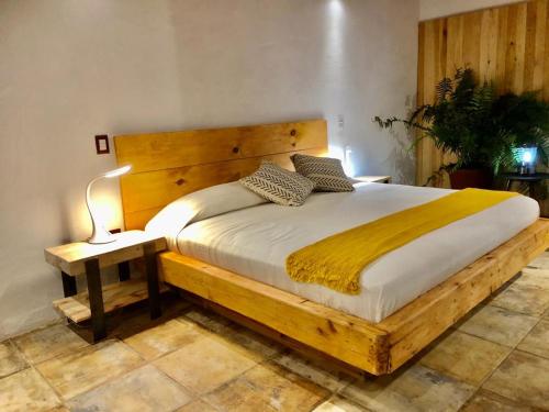 a bedroom with a wooden bed with a lamp on a table at Hotel Valle Místico in Tepoztlán