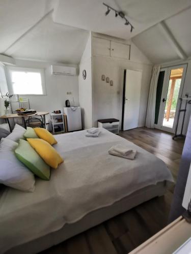 a bedroom with a large bed with yellow and green pillows at Apartment Maslina in Vrboska