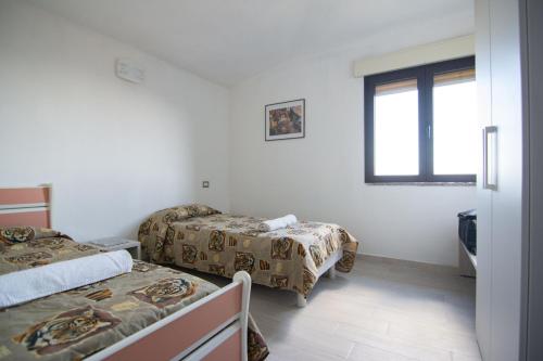 a room with two beds and a window at La Finestra Sul Mare in Lanusei