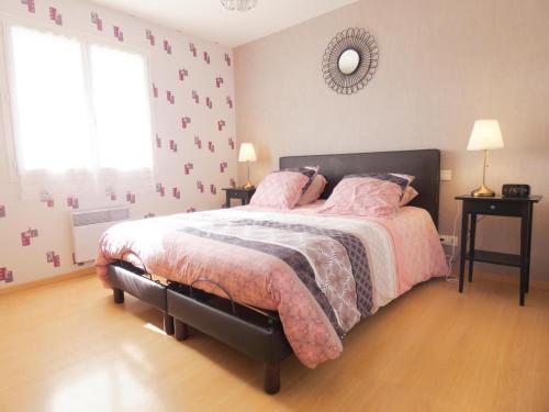 una camera da letto con un letto con lenzuola rosa e uno specchio di Le saoutot a Saint-Jean-de-Marsacq