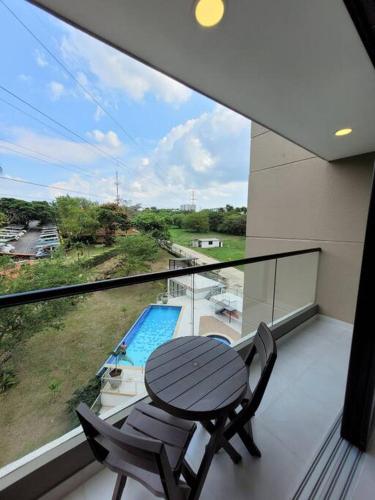 a balcony with a table and two chairs and a pool at Cali piso 4-06 Pance Apartamento Moderno Exclusivo Sector in Cali