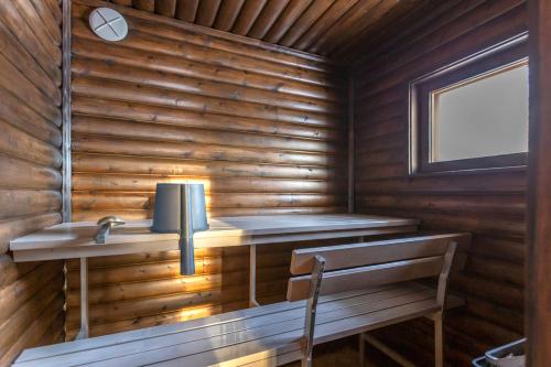 Cabaña de madera con lavabo y ventana en Kuukkeli Ivalo Arctic House, en Ivalo