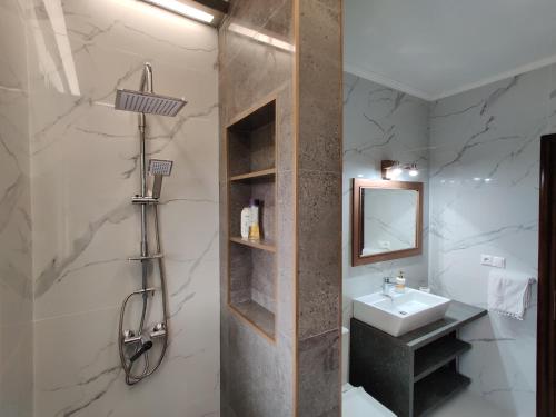 a bathroom with a sink and a shower and a mirror at Psatha by CorfuEscapes in Kynopiástai