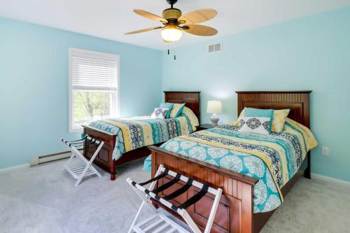 a bedroom with two beds and a ceiling fan at Stunning Pocono Lake Vacation Rental with Huge Deck! in Pocono Lake