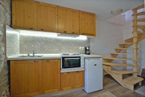 a kitchen with a sink and a microwave at To Patriko Mas Guesthouse-1 in Palaios Panteleimonas