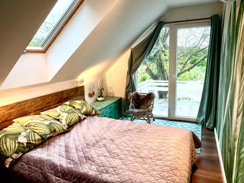 Bohemian eco lodge في Kisapáti: غرفة نوم بسرير ونافذة كبيرة