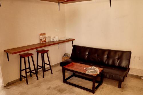 a living room with a couch and a bar with stools at Casa Nomada Tuxtla Hotel - Hostal in Tuxtla Gutiérrez