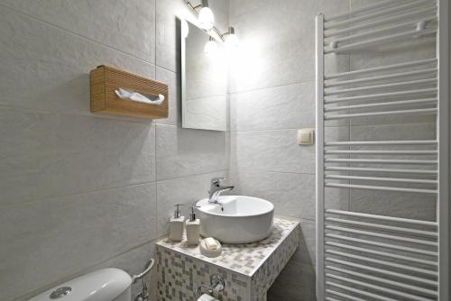 een witte badkamer met een wastafel en een douche bij To Patriko Mas Guesthouse-1 in Palaios Panteleimon