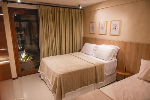 a hotel room with two beds and a window at Village aconchegante em Mucugê in Mucugê